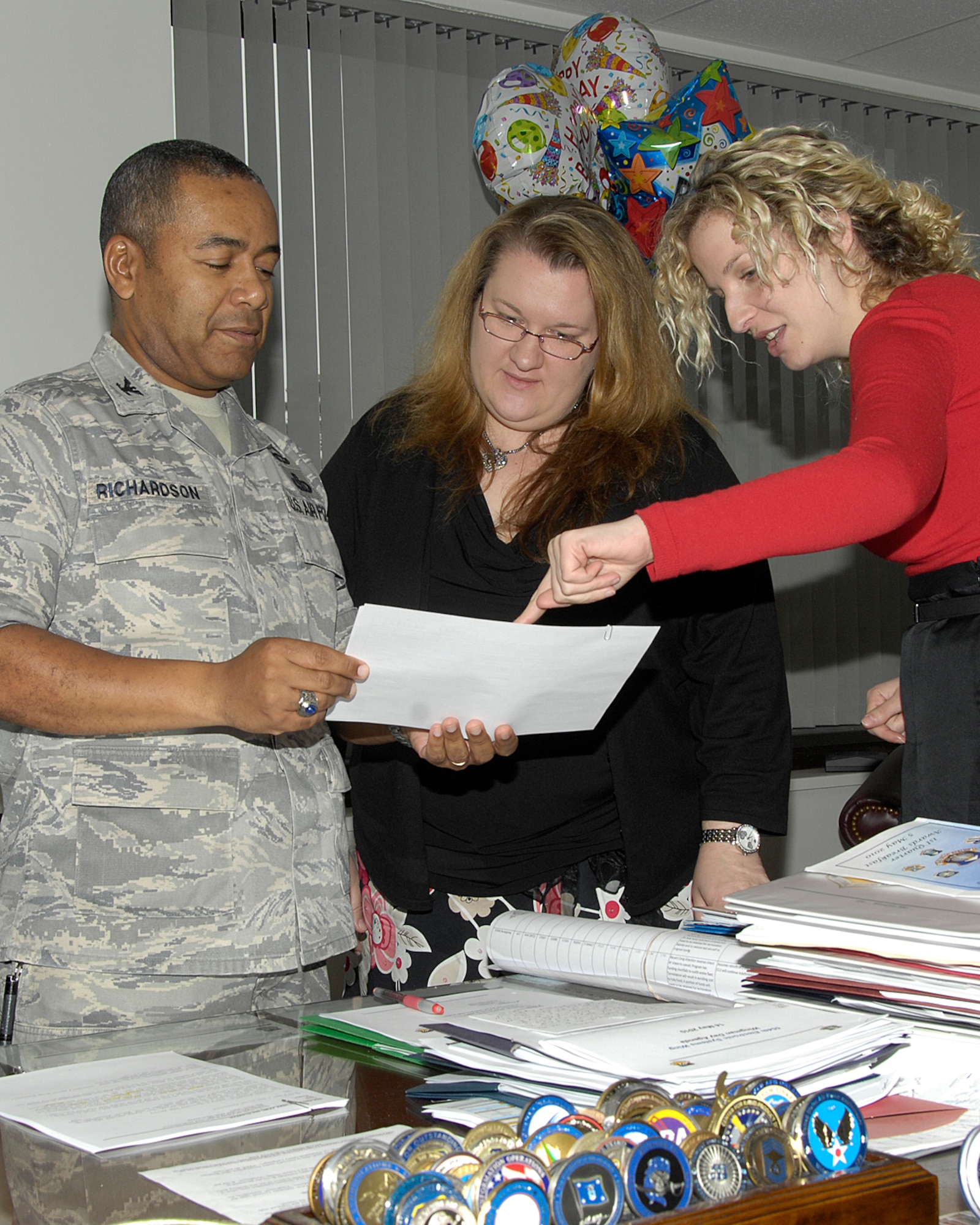 Col. Derrick M. Richardson, 554th Electronic Systems acting wing director, reviews his schedule with Danielle Opalka (center), executive officer, and Elizabeth Payne, executive assistant, May 19. Colonel Richardson is preparing to retire from the Air Force after more than 27 years of service. A retirement ceremony will be held June 4 at 1 p.m. at the Hanscom Minuteman Club.  (Photo by Linda LaBonte Britt) 

