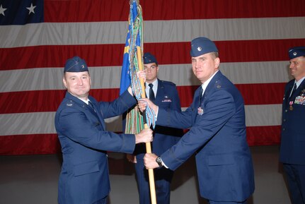 Col. Jimmy Donohue, 12th Operations Group commander, presents the 99th Flying Training Squadron guidon to new the incoming commander, Lt. Col. James Fisher, at the Change of Command Ceremony May 27 at Randolph Air Force Base, Texas. (U.S. Air Force photo by Steve White)