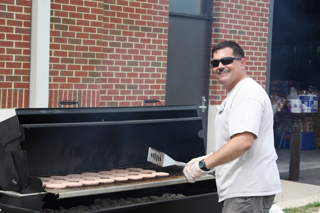 LANGLEY AIR FORCE BASE, Va. -- Master Sgt. James Pinto, 27th Intelligence Squadron intelligence systems flight superintendent, grills hamburgers and bratwurst for the Airmen who competed at the events held May 26 as part of the 480th Intelligence, Surveillance and Reconnaissance Wing Warrior Games. (U.S. Air Force photo/Master Sgt. Joseph Boyer) 
