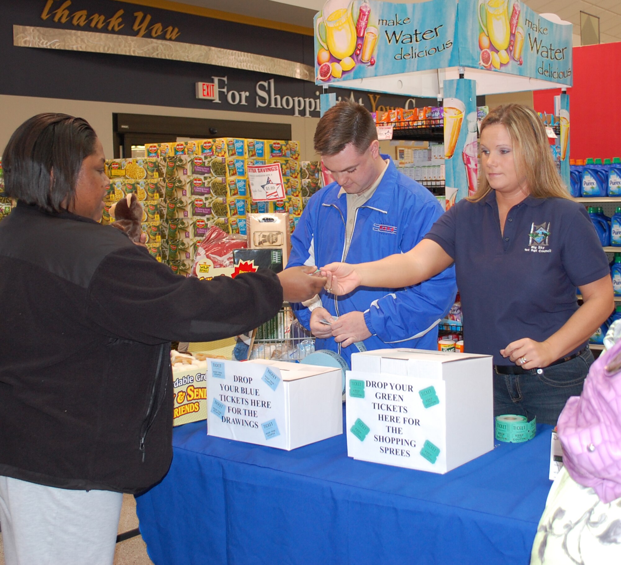 Omega Davis takes her ticket for a chance at a shopping spree from 341st Force Support Squadron first sergeant Master Sgt. Sheila Lawson. The Commissay, Airmand and Family Readiness Center, Topp III Association and First Sergeant's Council sponsored a fun event to honor wives of deployed Team Malmstrom members May 23. (U.S. Air Force photo/Valerie Mullett)
