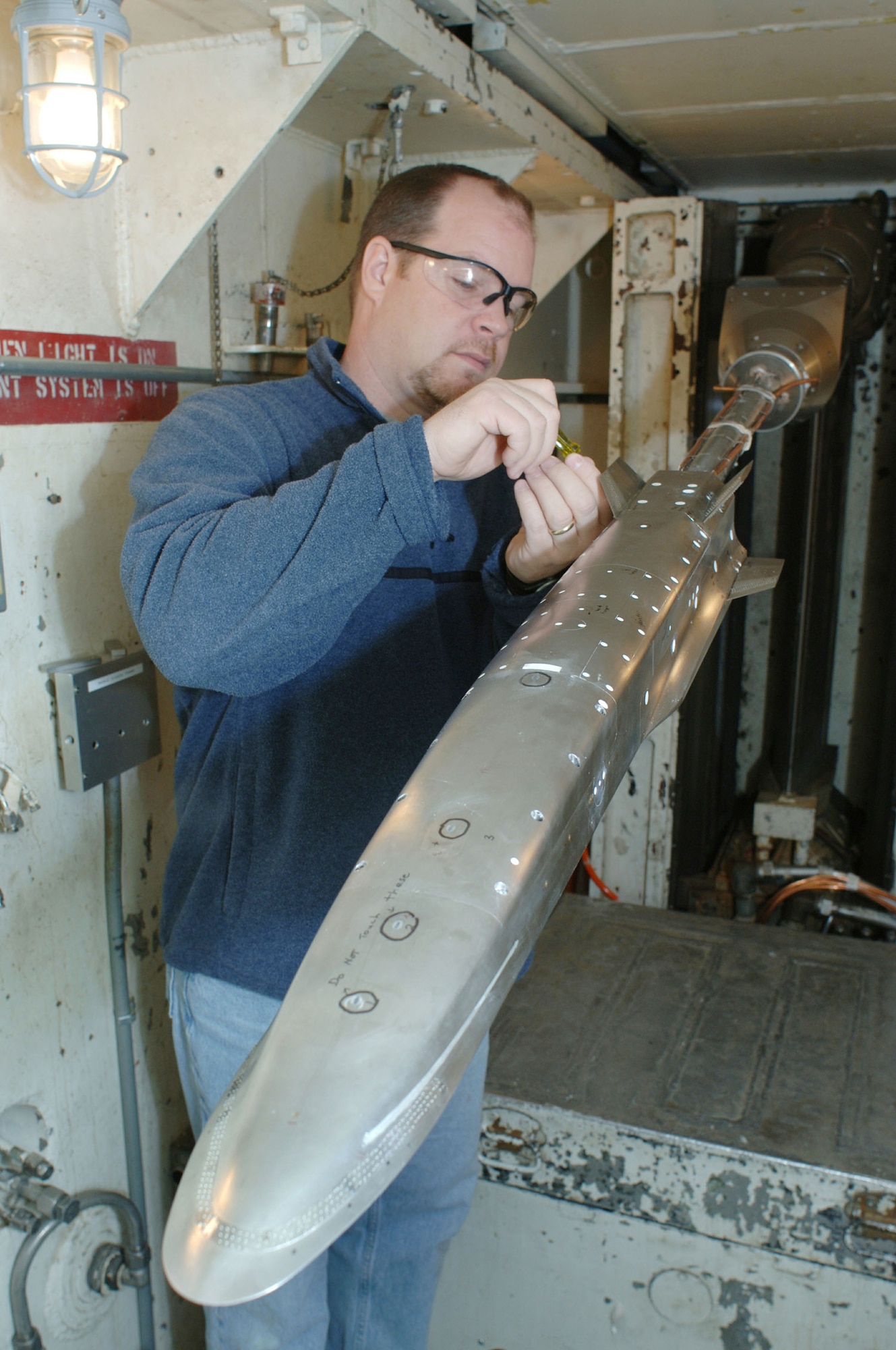 Carson McAfee, ATA outside machinist and foreman, makes a control surface change to the sub-scale model of the X-51 WaveRider during a break in aerodynamic testing at AEDC’s von Kármán Gas Dynamics Facility in 2006 . (File photo)
