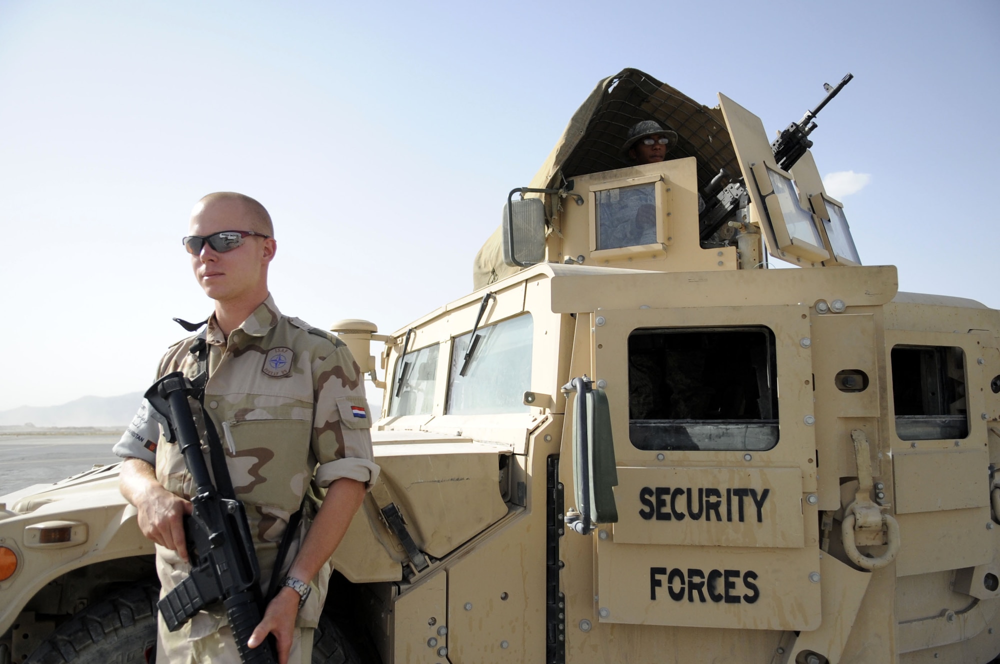 CPL1 Sander Wilpshaar, NATO security forces, and Senior Airman Ryan Davis, 451st Expeditionary Security Forces Squadron blocking force, stand watch over the flightline controlling any movement onto the flightline May 31 at Kandahar Airfield.   (U.S. Air Force photo by Senior Airman Nancy Hooks/Released)