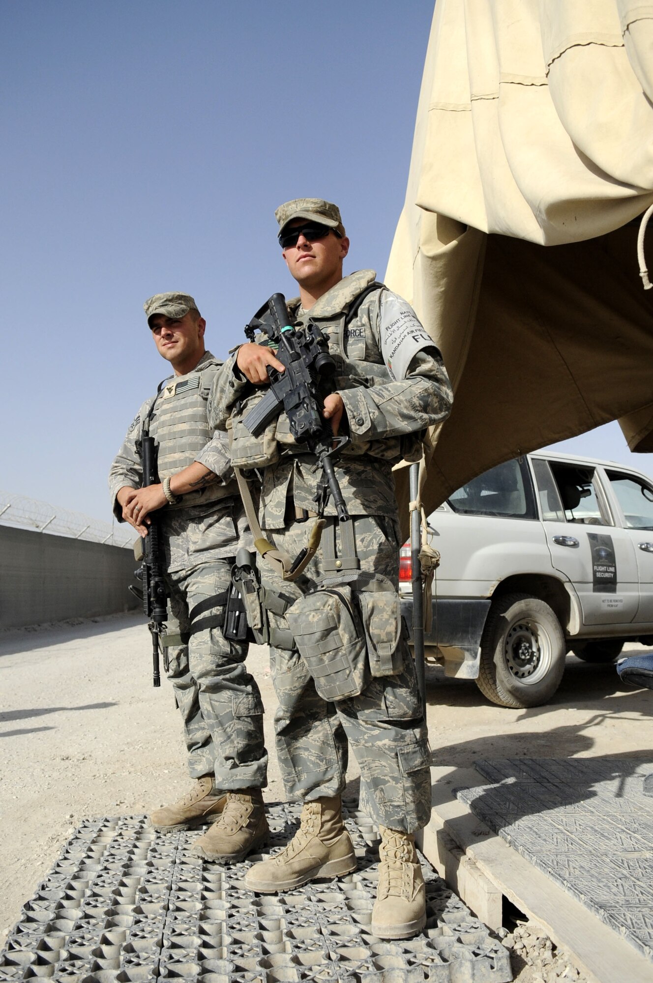 Airman 1st Class Eric Sprankle and Senior Airman Garrett Cochran, 451st Expeditionary Security Forces Squadron entry controller, post security at one of the entry control points at Kandahar Airfield, Afghanistan, May 31.  Airman Sprankle is stationed at Elmendorf AFB, AK and Airman Cochran is stationed at Goodfellow AFB, TX.  (U.S. Air Force photo by Senior Airman Nancy Hooks/Released)