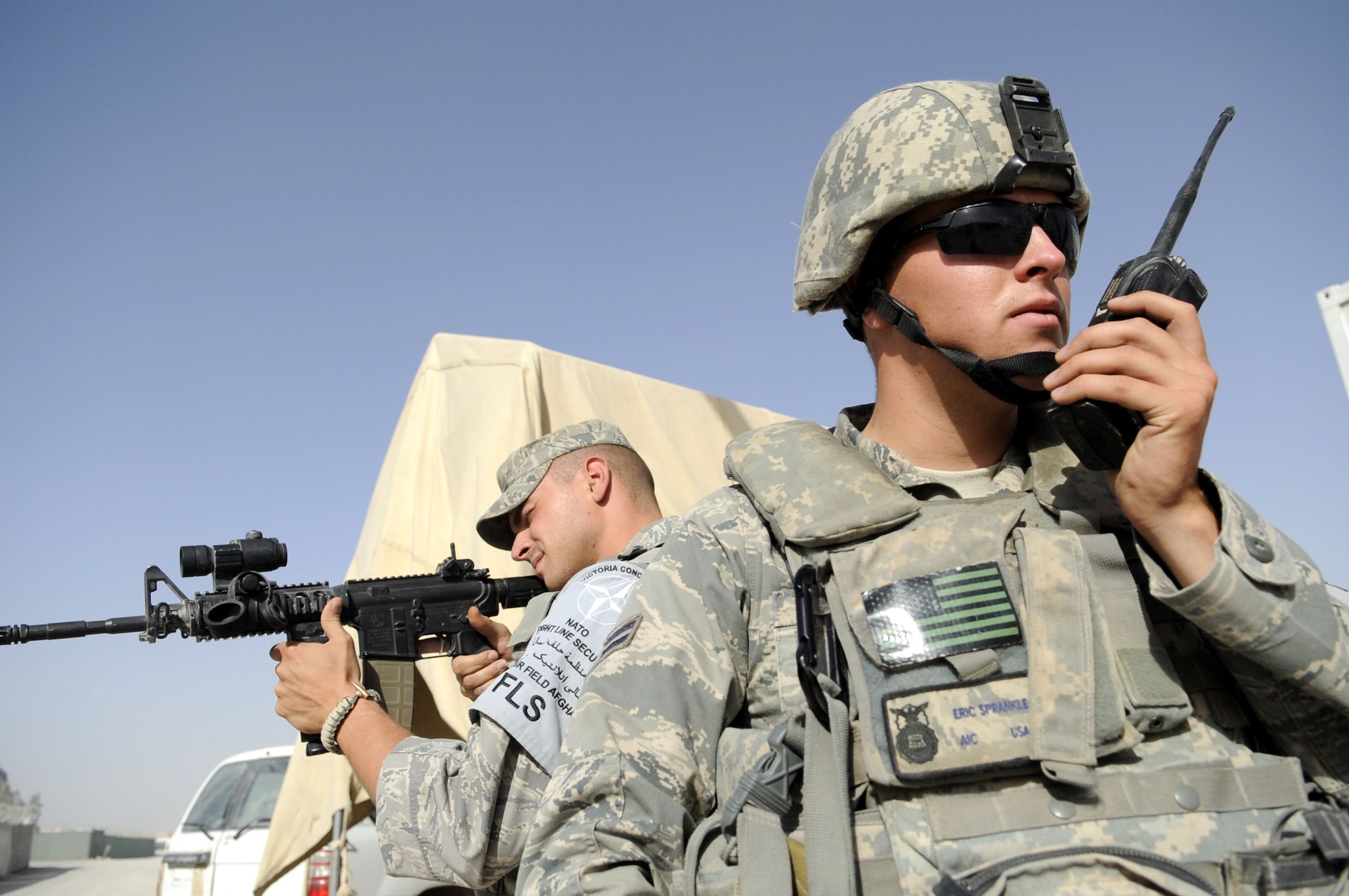 Airman 1st Class Eric Sprankle and Senior Airman Garrett Cochran, 451st Expeditionary Security Forces Squadron entry controller, post security at one of the entry control points at Kandahar Airfield, Afghanistan May 31.  Airman Sprankle is stationed at Elmendorf AFB, AK and Airman Cochran is at from Goodfellow AFB, TX.  (U.S. Air Force photo by Senior Airman Nancy Hooks/Released)