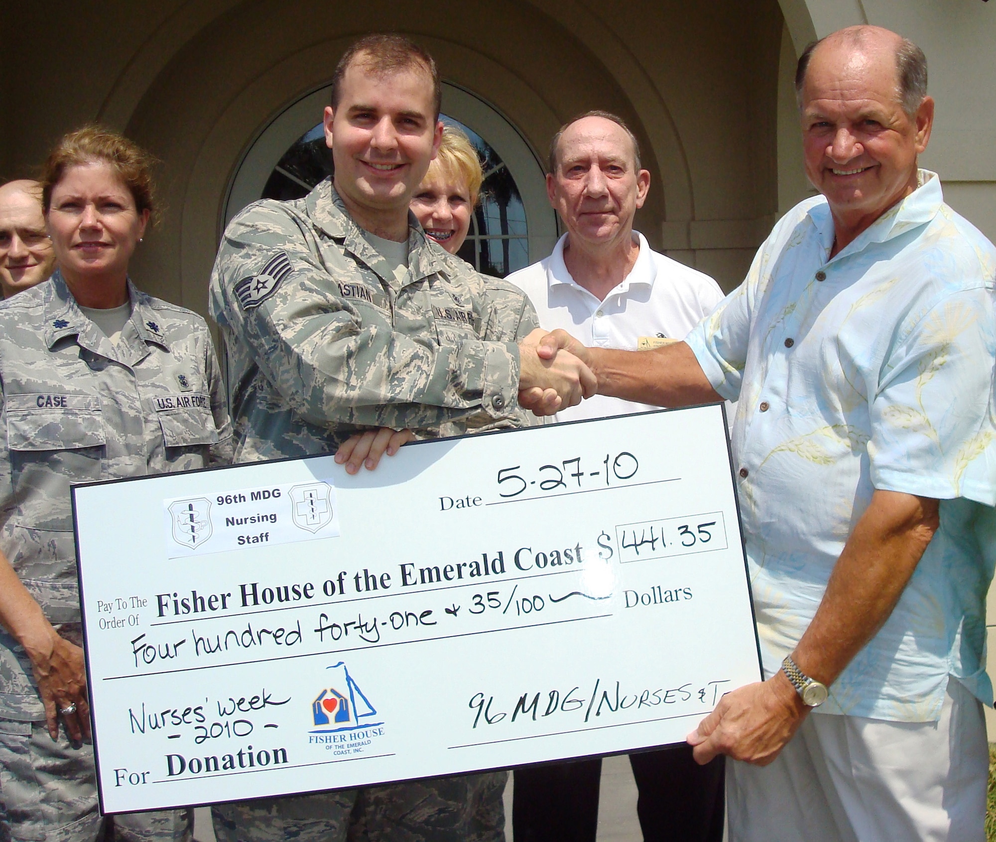 Staff Sgt. Dallin Bastian, a technician with the 96th Surgical Operations Squadron, presents a check to Fisher House executive board president, Joe Oder, May 27.  The check represents donations from nurses and nurse technicians in honor of National Nurses' Week. (USAF photo)