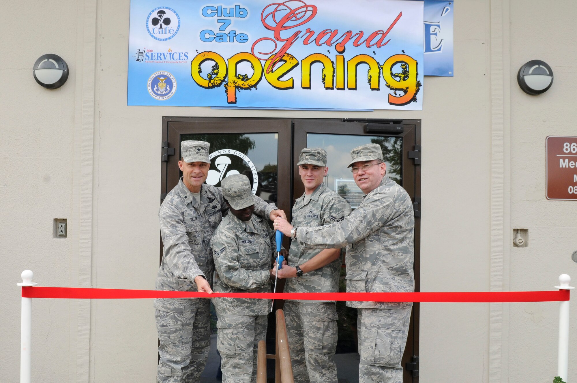 (Left to Right) U.S. Air Force Brig. Gen. Mark Dillon, 86th Airlift Wing commander, Airman 1st Class Ashley Williams, Landstuhl Regional Medical Center, Airman 1st Class Jacob Woodel, 786th Civil Engineer Squadron, and Col. Harry Mathis III, 86th Wing Chaplain, cut the ceremonial ribbon during the Club 7 grand opening, Ramstein Air Base, Germany, June 1, 2010. The Chapel established Club 7 due to a new Air Force initiative to provide an effective venue, ministering to the spiritual and physical needs of single Airmen. (U.S. Air Force photo by Airman 1st Class Brittany Perry)