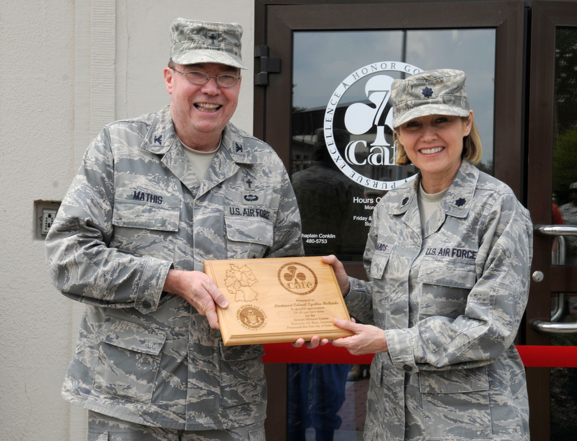 U.S. Air Force Lt. Col. Cynthia Richards, 86th Airlift Wing director of staff, receives a plaque in appreciation from Col. Harry Mathis III, 86th Wing Chaplain, during the Club 7 grand opening, Ramstein Air Base, Germany, June 1, 2010. The Chapel established Club 7 due to a new Air Force initiative to provide an effective venue, ministering to the spiritual and physical needs of single Airmen. (U.S. Air Force photo by Airman 1st Class Brittany Perry)
