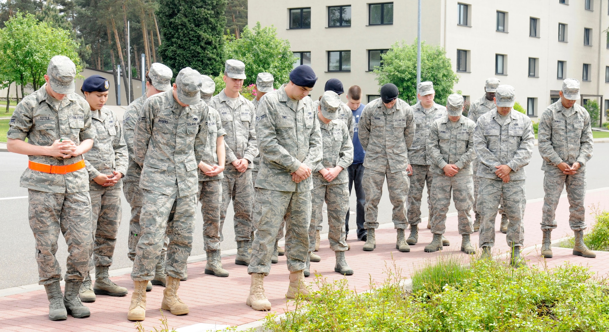 U.S. Air Force Airmen from the First Term Airmen Center bow their heads during a prayer given at the Club 7 grand opening, Ramstein Air Base, Germany, June 1, 2010. The Chapel established Club 7 due to a new Air Force initiative to provide an effective venue, ministering to the spiritual and physical needs of single Airmen. (U.S. Air Force photo by Airman 1st Class Brittany Perry)