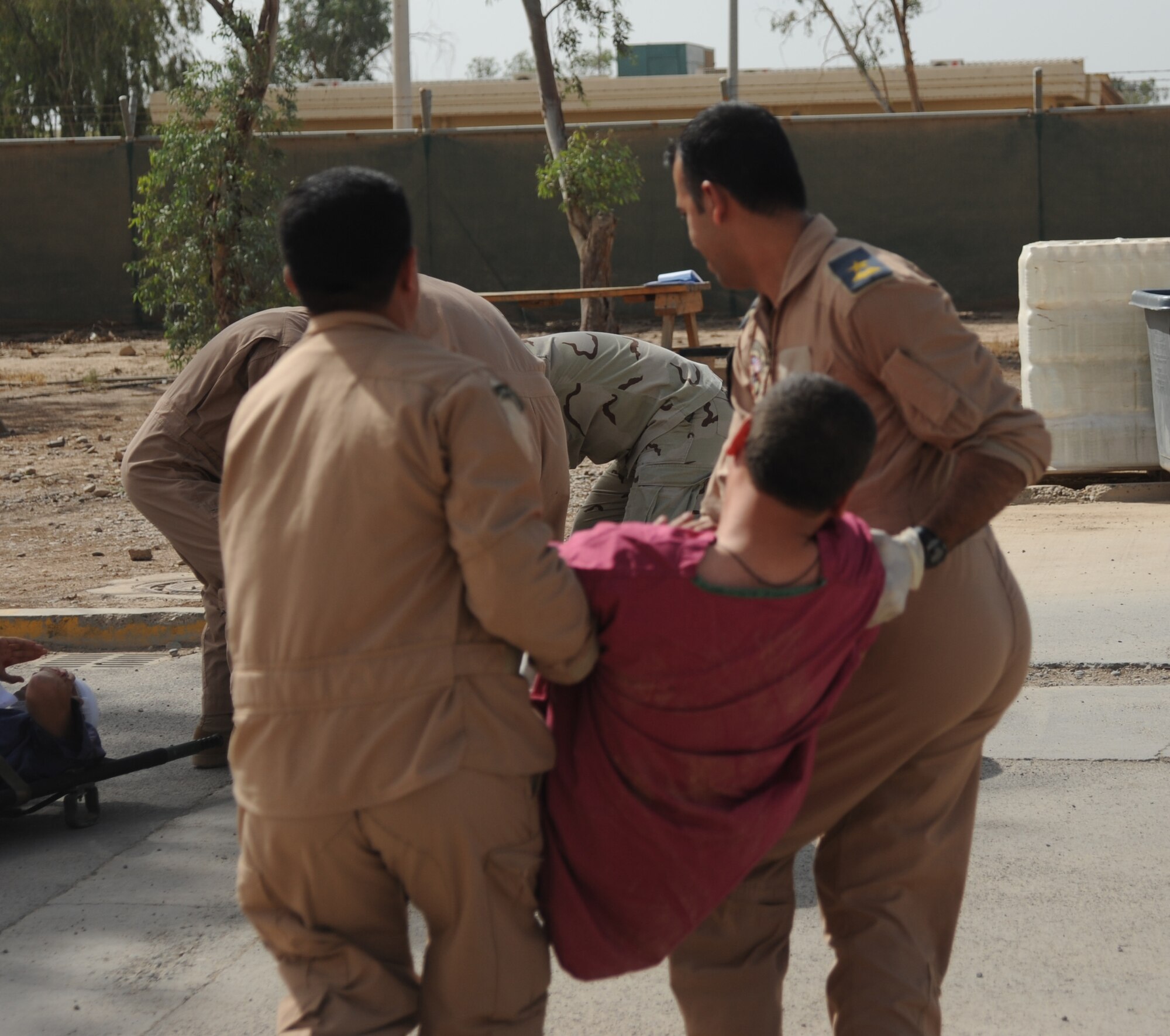 Iraqi military members carry a victim with simulated injuries to safe point to provide him with medical treatment during a training exercise May 20, 2010. Iraqi forces from Al-Muthana, Camp Taji, and New Al-Muthana participated in an exercise that demonstrated their abilities to asses and treat different conditions that may happen in a combat environment. 