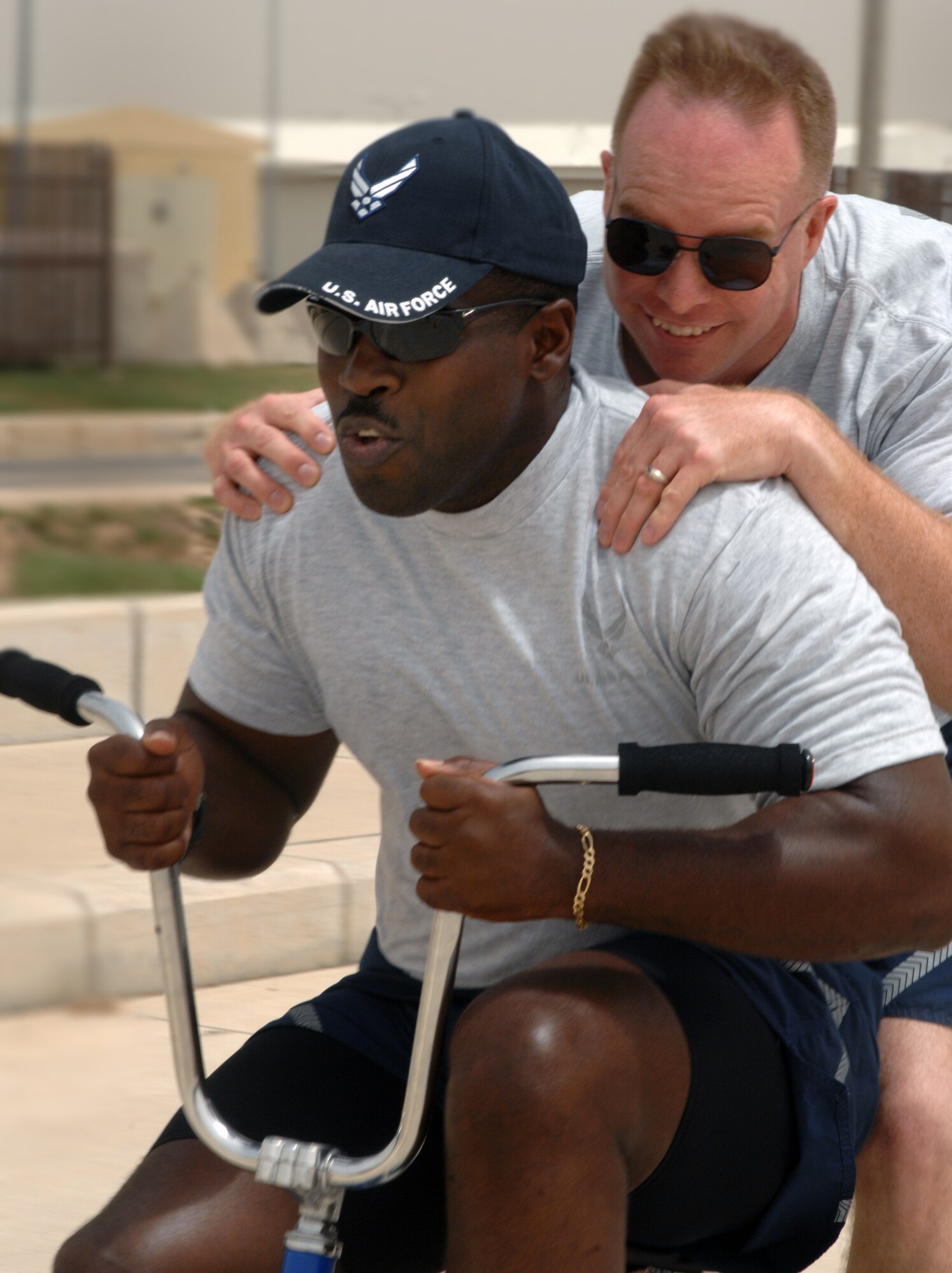 Col. Eric Beene, 39th Air Base Wing commander, rides on the back of Chief Master Sgt. Marcus Snoddy’s, 39th ABW command chief, tricycle during a tricycle race as part of Wingman Day Friday, May 28, 2010 at Incirlik Air Base, Turkey. Wingman Day is an annual event bringing Airmen together through sports and recreation to focus on what it truly means to be a wingman. As part of Incirlik’s Wingman Day, Airmen from every squadron participated against each other in friendly games of volleyball, human foosball, a human wrecking ball and tricycle racing. (U.S. Air Force photo/Senior Airman Sara Csurilla)