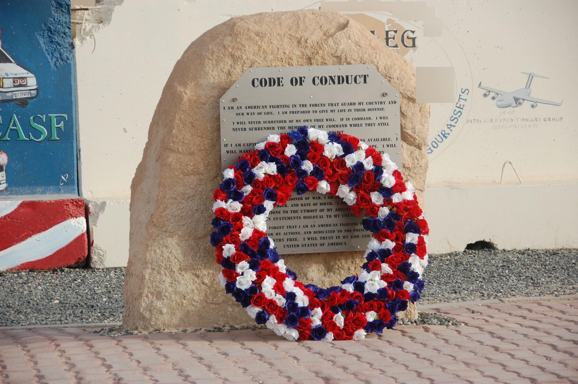 During a solemn Memorial Day ceremony here May 31, 2010, Airmen from the 386th Air Expeditionary Wing honored servicemembers who have made the ultimate sacrifice in the defense of the United States. A wreath to honor the fallen was placed against a Code of Conduct plaque near the base flagpole by 386th AEW senior leaders following a retreat ceremony and prayer of remembrance. Later, "Taps" was played by a bugler and "Amazing Grace" was played by two bagpipers as part of the special service. (U.S. Air Force photo illustration by Staff Sgt. Lakisha A. Croley/Released)