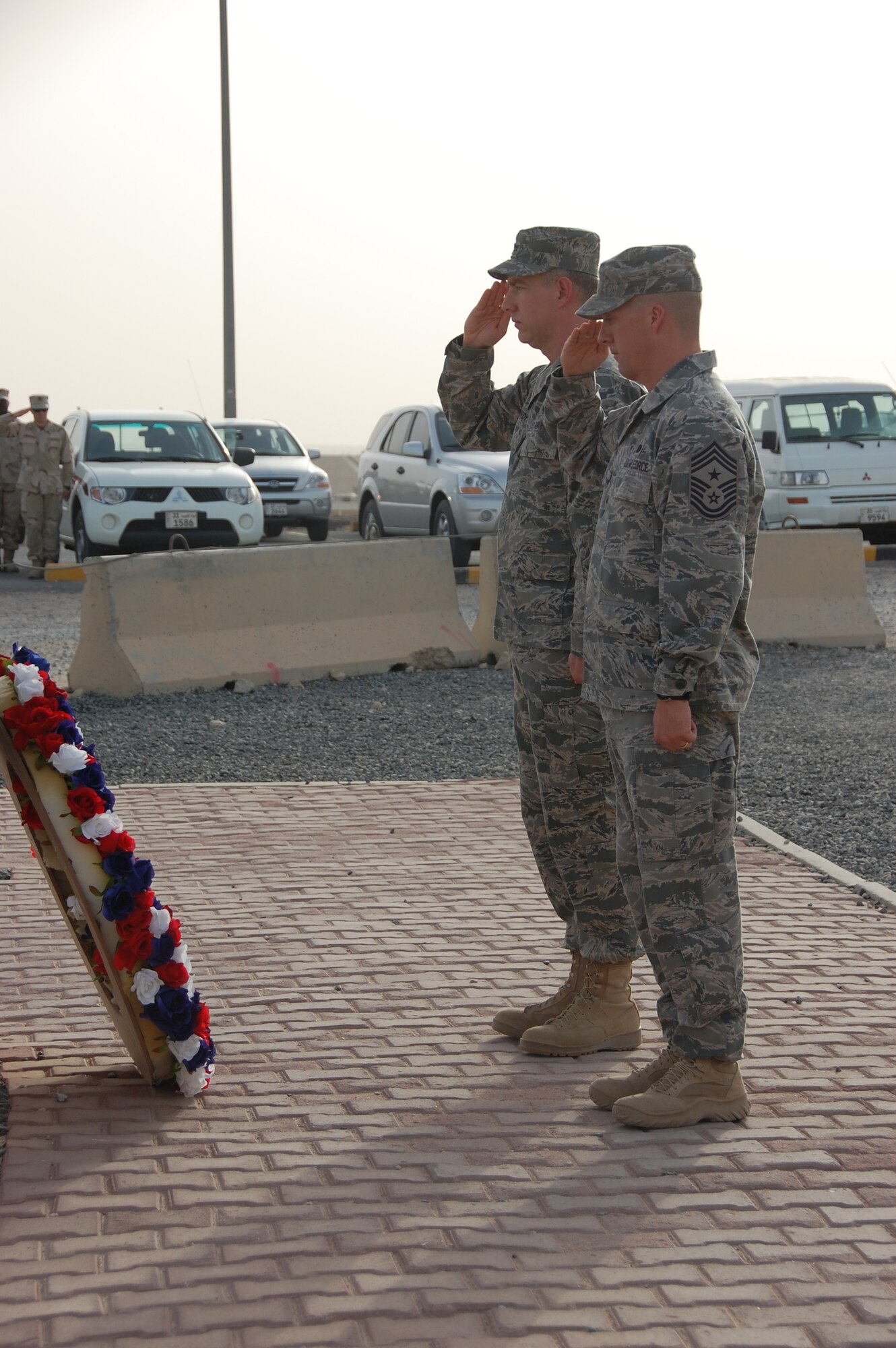 SOUTHWEST ASIA - From left, U.S. Air Force Command Chief Master Sgt. Douglas McIntyre and Col. John Gordy, II, 386th Air Expeditionary Wing commander, honor servicemembers who have made the ultimate sacrifice in the defense of the United States. The pair laid a wreath near the base flagpole at a special Memorial Day retreat ceremony here May 31, 2010. More than 100 military, civil service and contractor personnel were on hand to pay tribute to those who have made the ultimate sacrifice in the defense of the United States. (U.S. Air Force photo by Staff Sgt. Lakisha A. Croley/Released)