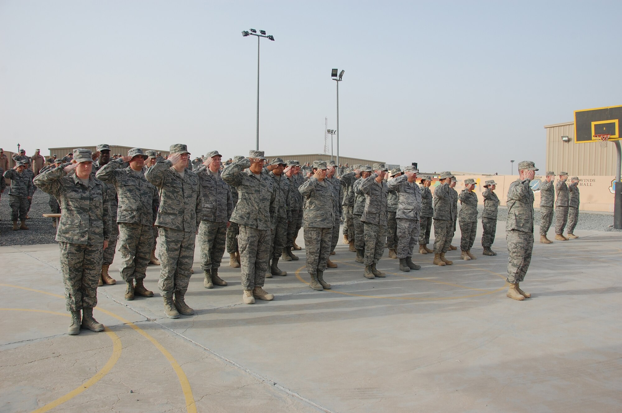 SOUTHWEST ASIA - Airmen from the 386th Air Expeditionary Wing pay respect to the U.S. flag at a special Memorial Day retreat ceremony here May 31, 2010 at an air base. More than 100 military, civil service and contractor personnel were on hand to pay tribute to those who have made the ultimate sacrifice in the defense of the United States. (U.S. Air Force photo by Staff Sgt. Lakisha A. Croley/Released)
