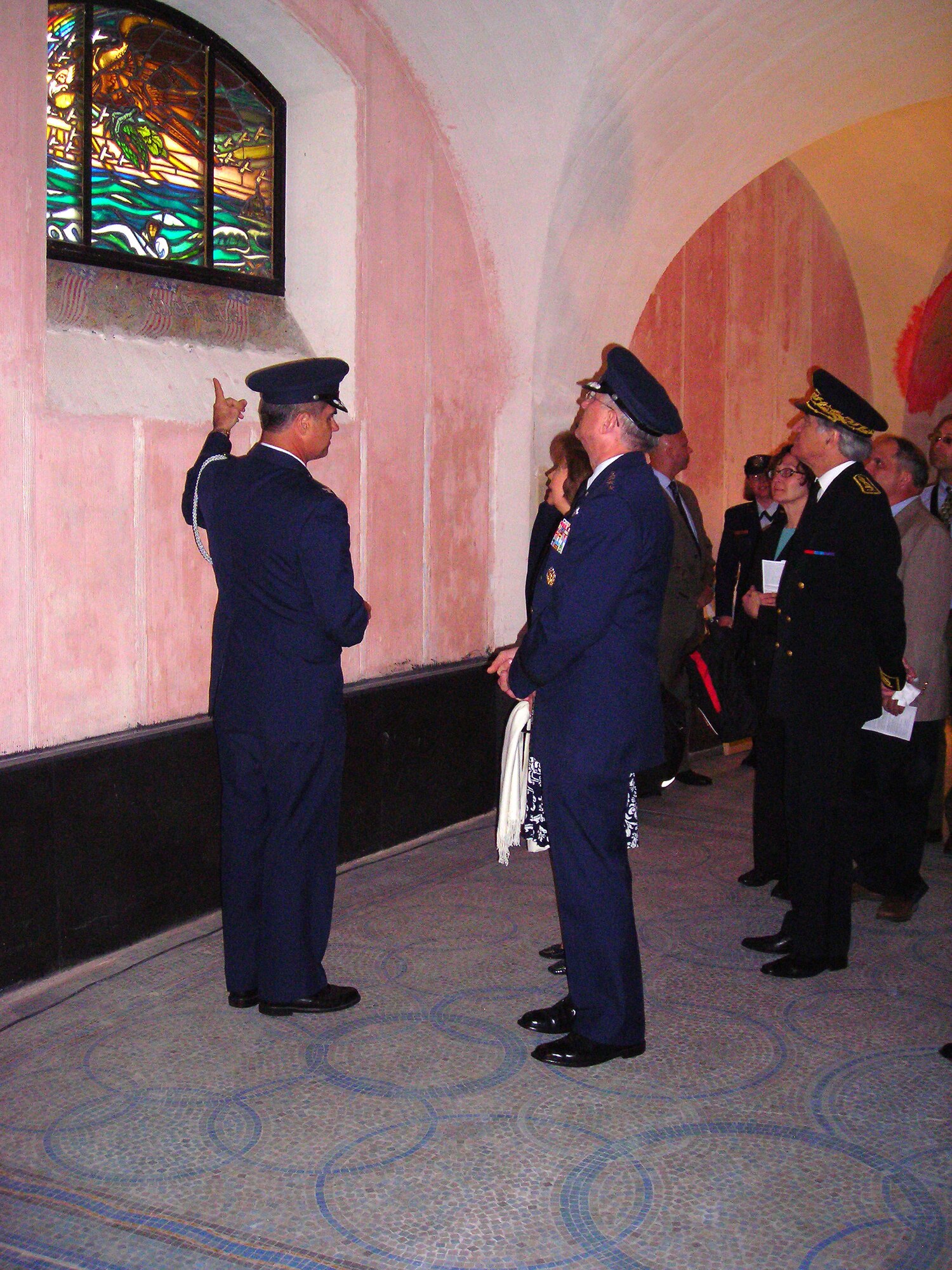 PARIS - Col. Robert Dooley, Air Attache at the U.S. Embassy in Paris, explains to Gen. Roger Brady, U.S. Air Forces in Europe commander, and guests the significance of the stained glass windows in the crypt beneath the Lafayette Escadrille Memorial outside of Paris, May 27, 2010. U.S. and French civilian and military leaders paid their respects to America's first combat pilots during the event, which also featured an aircraft flyover and ceremonial music. The Lafayette Escadrille Memorial is a reminder for all of the American pilots of the Escadrille La Fayette and the Lafayette Flying Corps who died during service to the Allies during World War I. (U.S. Air Force photo/Capt. Tony Wickman)