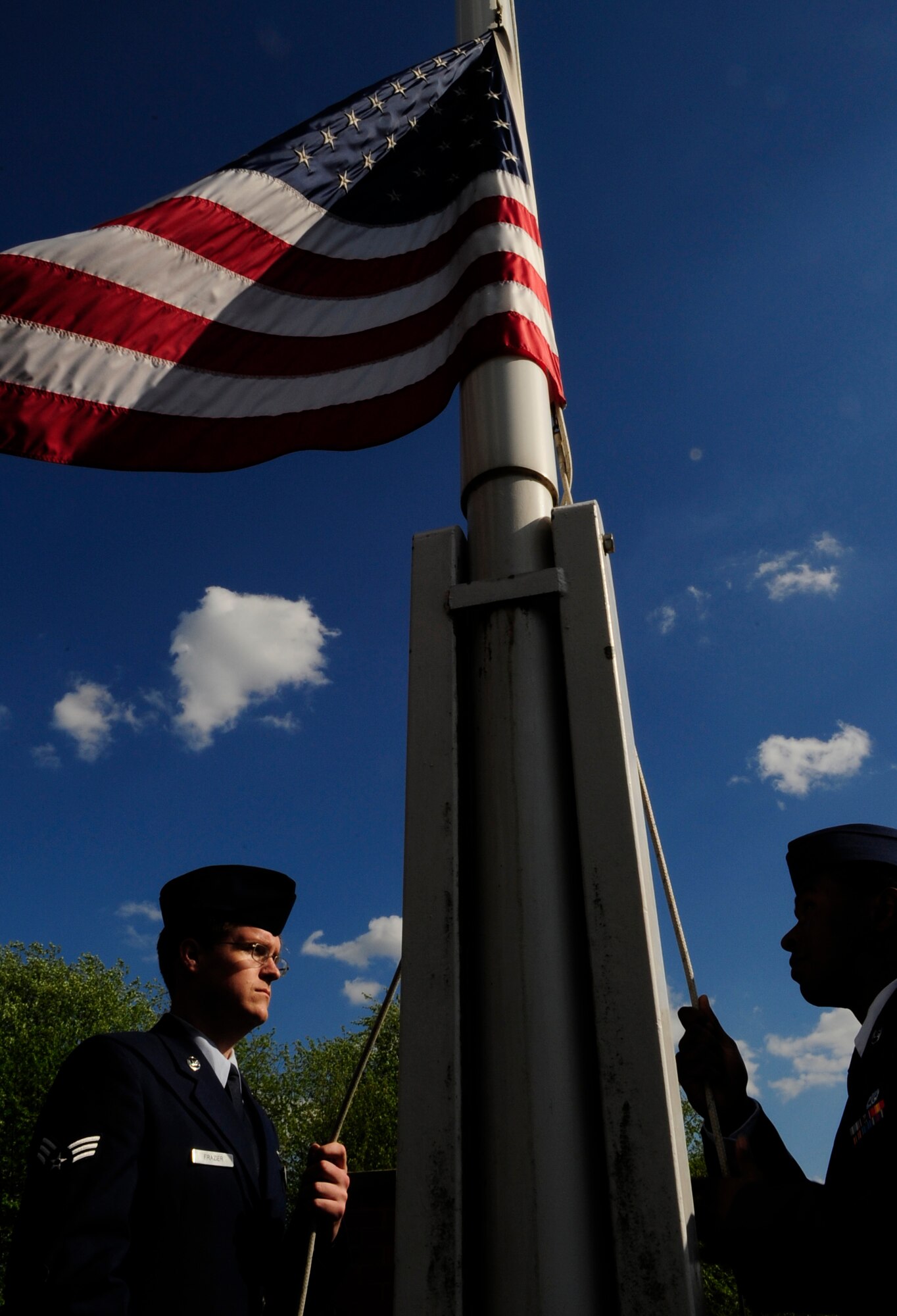 RAF MILDENHALL, England – Senior Airman Ryan Frazier, 488th Intelligence Squadron, takes down the flag at the end of the duty day May 28.  The retreat commenced the beginning of Memorial Day weekend, a national holiday to honor fallen military members from past wars.  (U.S. Air Force photo/Staff Sgt. Christopher L. Ingersoll)