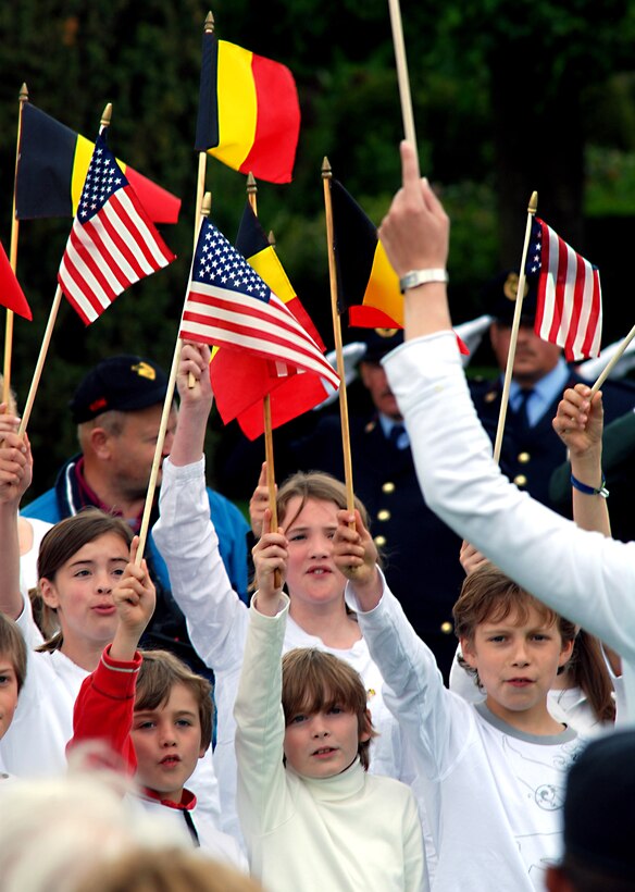 Belgian school children sing the Belgian and American national anthems while they wave the flags of each nation during the Memorial Day ceremony at the Netherlands American Cemetery and Memorial in Margraten, Belgium, May 30, 2010. 