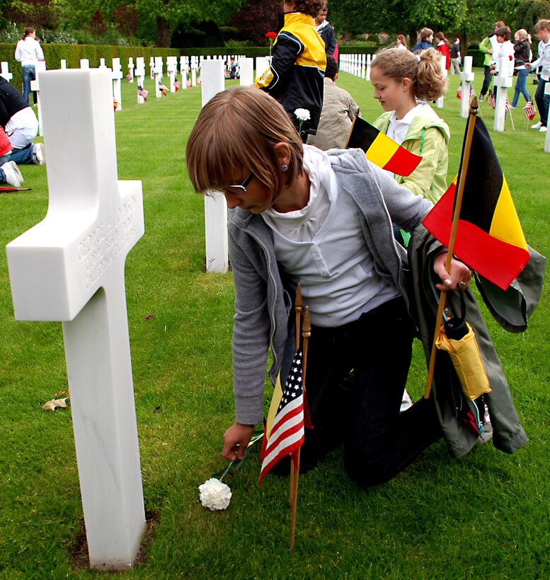 At the Memorial Day ceremony at Flanders Field American Cemetery, May 30, 2010, Belgian school children lay flowers on the graves of American soldiers who died during World War I.