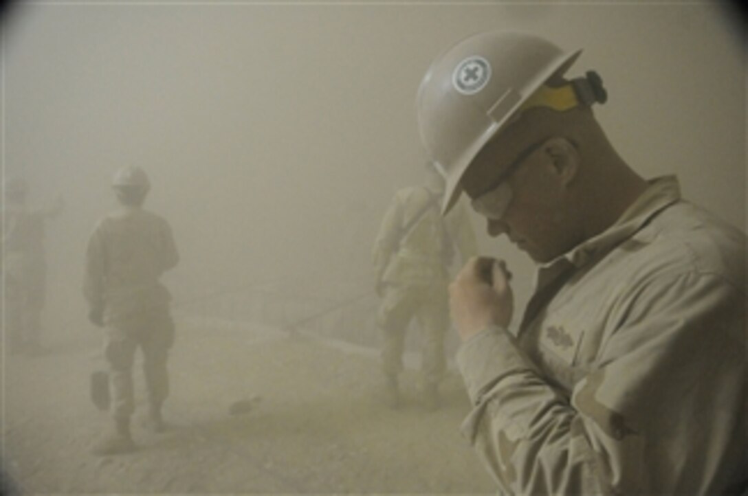 U.S. Navy Petty Officer 2nd Class Eric Clark, a Seabee attached to Naval Mobile Construction Battalion 5, is caught in a sandstorm at Camp Leatherneck, Afghanistan, on May 4, 2010.  Naval Mobile Construction Battalion 5 was deployed to Afghanistan to execute general engineering, infrastructure construction and project management in support of Operation Enduring Freedom.  