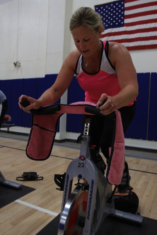 Nickie Dietz keeps a steady pace during a spin class Wednesday morning at the East Gym and Fitness Center. Spin, power yoga, Pilates, kickboxing and dance Zumba are a few of the aerobics classes available aboard the Combat Center.