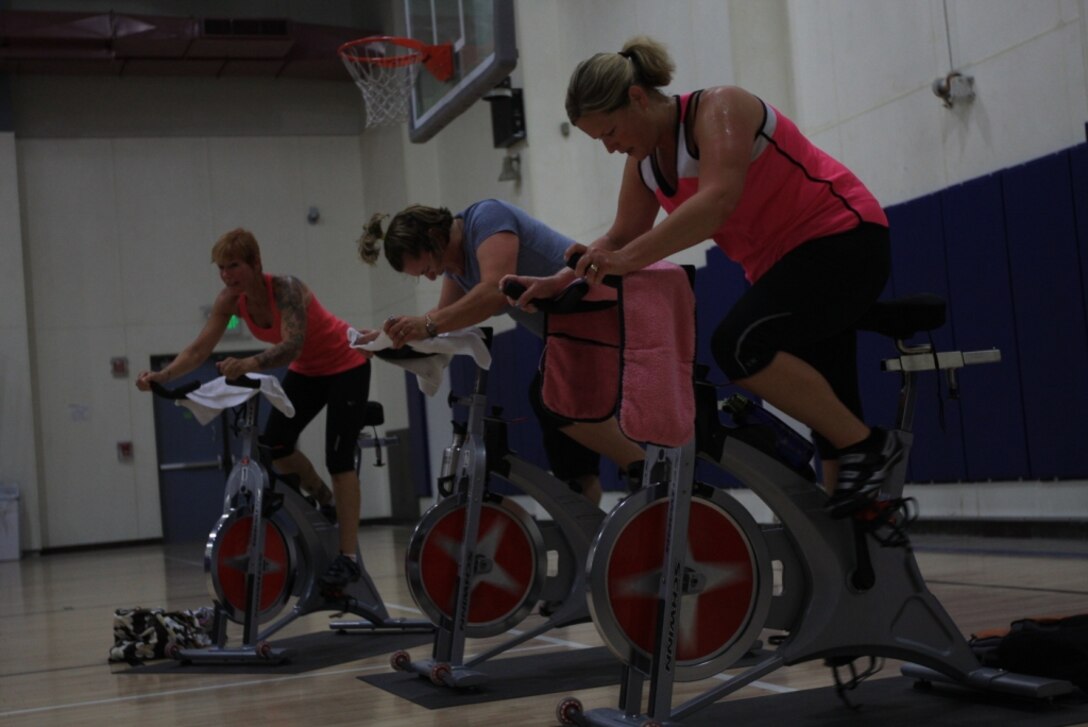 Women race through a more difficult part of a spin class at the East Gym and Fitness Center June 2. Spin is one of the many classes available through the Aerobics Program aboard the Combat Center.