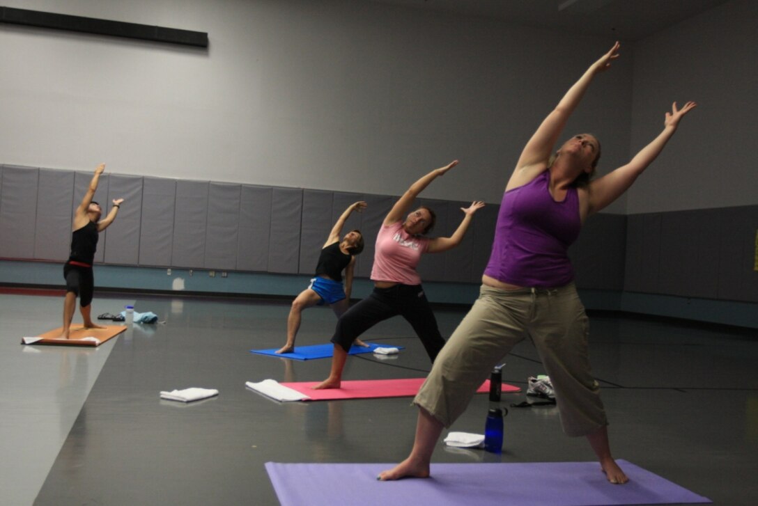 Women participating in the power yoga class run through various stretches and exercise at the Community Center June 2. Power yoga is one of the many aerobics workouts available to Combat Center families through the Aerobics Program.