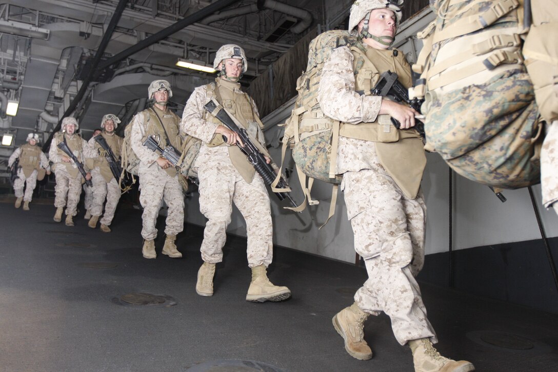 Marines with Company C, 1st Battalion, 7th Marine Regiment, run down a ramp to stage their gear June 3 aboard the USS Bonhomme Richard. The exercise, known as Dawn Blitz, was used by 1st Bn., 7th Marines, as practice before their deployment with the 31st Marine Expeditionary Unit next month.