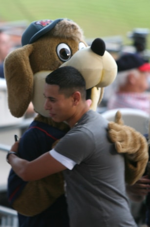 A Marine gives a good-natured pat on the back to the Kinston Indians mascot following a dance off in between innings during the game at Grainger Stadium in Kinston, N.C., June, 2, 2010.  The mascot and the Marine had just competed against each other, with the mascot pronounced as the hands-down winner.