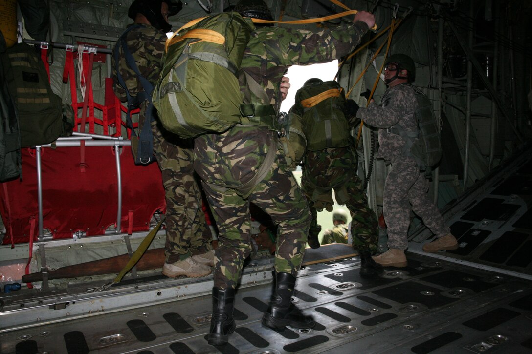 U.S. Army Sgt. 1st Class Eric Perham, right, a jumpmaster from U.S. Army Europe, motivates Romanian static-line paratroopers jumping from a U.S. Marine Corps KC-130T Hercules aircraft from Marine Aerial Refueler Transport Squadron 234, June 2. Perham and two other U.S. Army jumpmasters provided their expertise to the airborne training conducted by U.S. and Romanian forces, June 2-3.