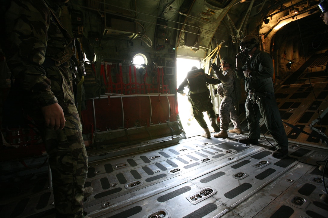 U.S. Army Sgt. 1st Class Eric Perham, a jumpmaster from U.S. Army Europe, motivates Romanian static-line paratroopers jumping from a U.S. Marine Corps KC-130T Hercules aircraft from Marine Aerial Refueler Transport Squadron 234, June 2. Perham and two other U.S. Army jumpmasters provided their expertise to the airborne training conducted by U.S. and Romanian forces, June 2-3.