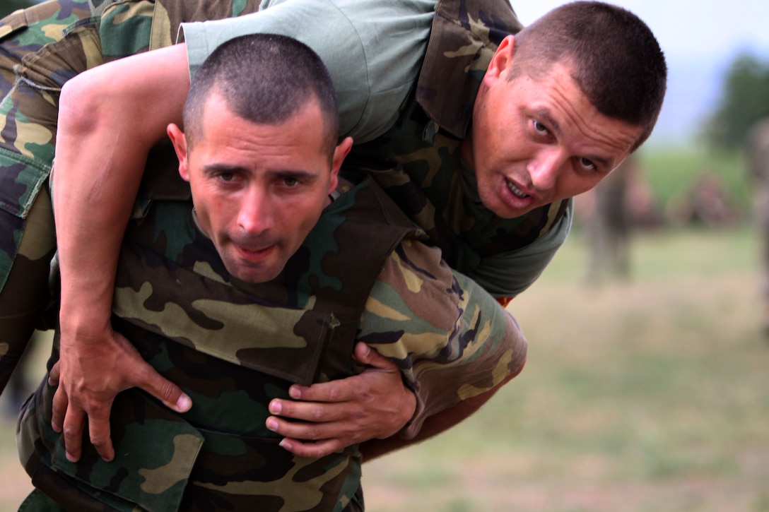 Sgt. Slagan Cvetanovski, a Macedonian Army soldier with Scorpion Company, 1st Battalion, 1st Brigade, carries Staff Sgt. Dalebor Jovanovski, also with Scorpion Co., 1st Bn., 1st Brigade, during a competitive Marine Corps Martial Arts Program training exercise at Babadag Training Area, Romania, June 2. The Macedonians have proven to be as competitive as Marines and make it evident by making each training exercise a competition between the four platoons.
