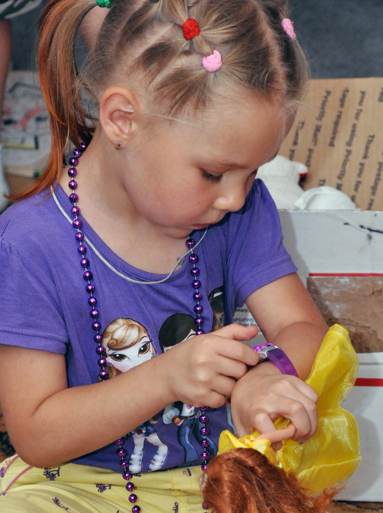 A girl from Nadjeshda Orphanage checks her new watch while playing with dolls and toys from Airmen at the Transit Center at Manas, Kyrgyzstan June 2, 2010. Transit Center Airmen often work with local charities to support the greater Bishkek area and communities near the installation. Outreach efforts include work with orphanages, medical facilities for children, elderly foundations and Habitat for Humanity. Airmen have supported Nadjeshda for the last six years, helping rebuild and repair the facility and spending time with the children. (U.S. Air Force photo/Staff Sgt. Carolyn Viss)
