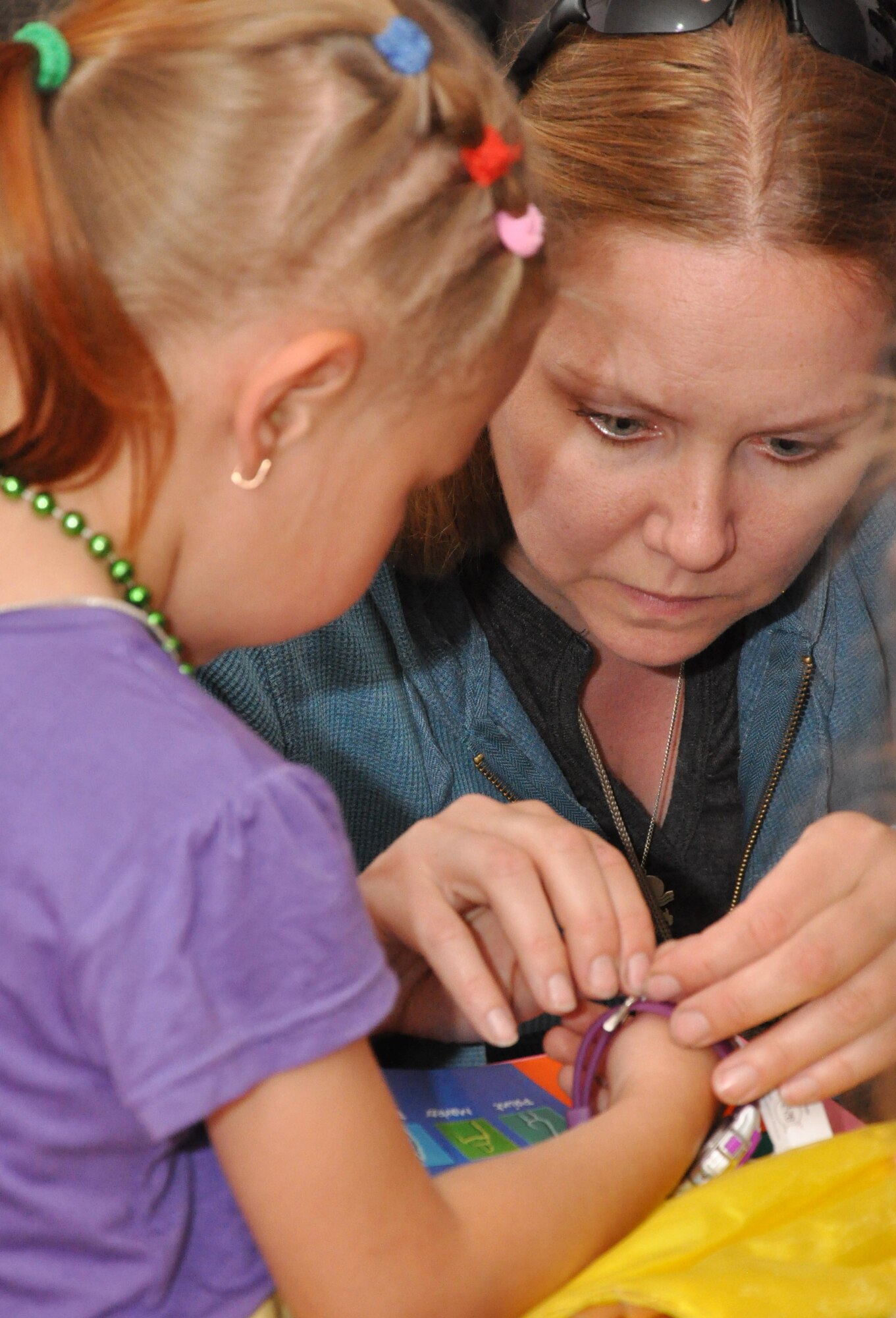 Senior Airman Cheryl Flores, an Airman from the Transit Center at Manas, Kyrgyzstan, helps a little girl from Nadjeshda Orphanage put on a new watch during a humanitarian assistance visit June 2, 2010. Transit Center Airmen often work with local charities to support the greater Bishkek area and communities near the installation. Outreach efforts include work with orphanages, medical facilities for children, elderly foundations and Habitat for Humanity. (U.S. Air Force photo/Staff Sgt. Carolyn Viss)