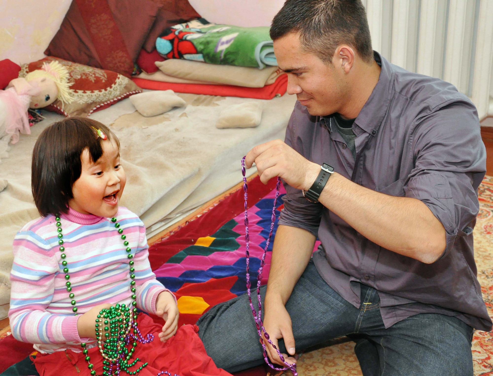 Senior Airman James Gomez, an Airman from the Transit Center at Manas, Kyrgyzstan, gives a girl from Nadjeshda Orphanage some costume jewelry during a humanitarian assistance visit June 2, 2010. Transit Center Airmen often work with local charities to support the greater Bishkek area and communities near the installation. Outreach efforts include work with orphanages, medical facilities for children, elderly foundations and Habitat for Humanity. (U.S. Air Force photo/Staff Sgt. Carolyn Viss)