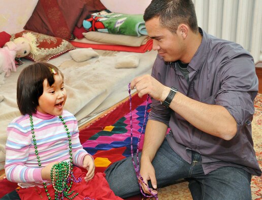 Senior Airman James Gomez, an Airman from the 20th Logistics Readiness Squadron at Shaw Air Force Base, gives a girl from Nadjeshda Orphanage some costume jewelry during a humanitarian assistance visit June 2, 2010. Airman Gomez is currently deployed to the Transit Center at Manas, Kyrgyzstan. Transit Center Airmen often work with local charities to support the greater Bishkek area and communities near the installation. Outreach efforts include work with orphanages, medical facilities for children, elderly foundations and Habitat for Humanity. (U.S. Air Force photo/Staff Sgt. Carolyn Viss)