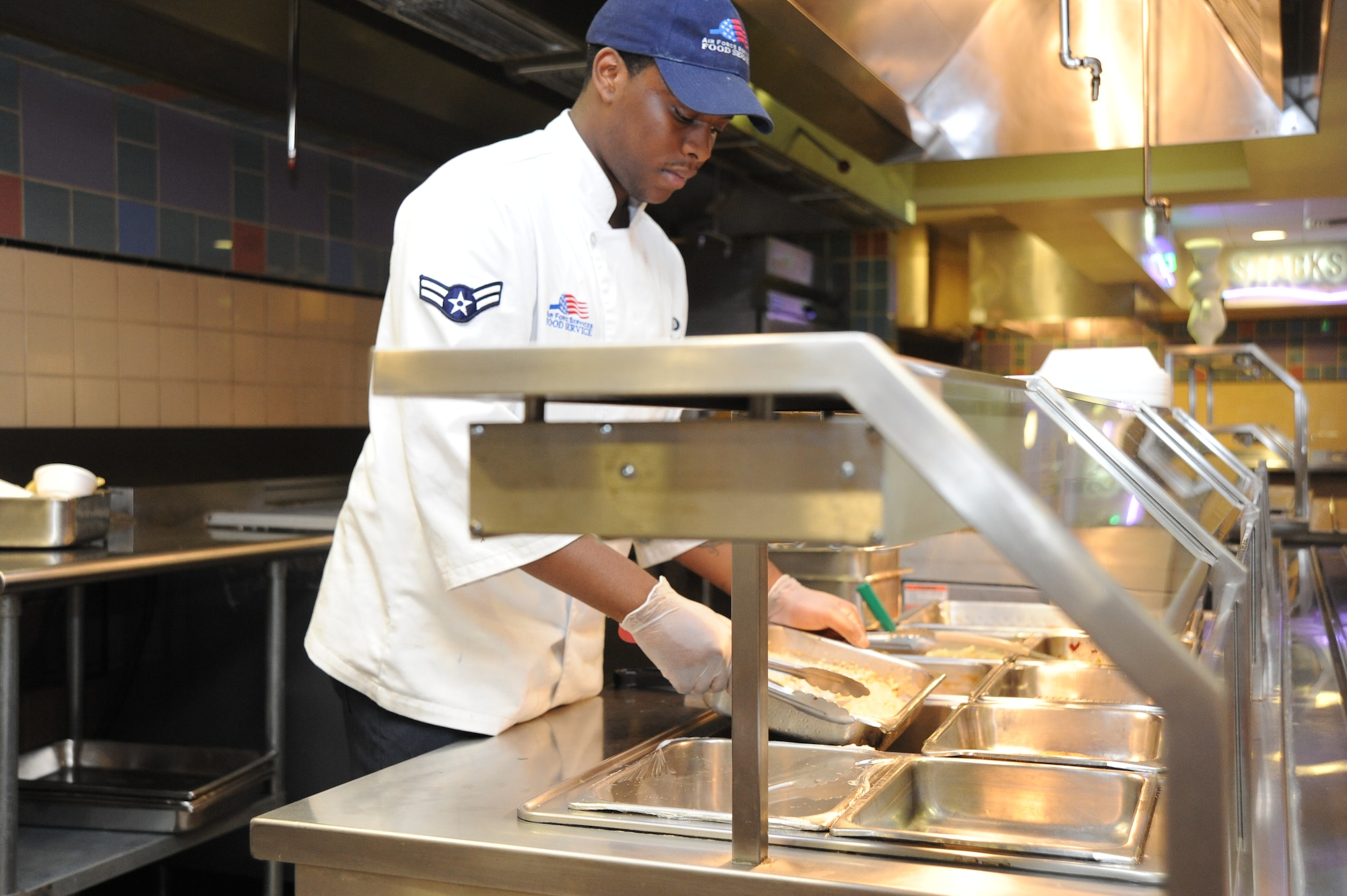 Airman 1st Class Kelly Legion, 22nd Force Support Squadron food service craftsman, prepares the food line for a midnight meal at Chisholm Trail Inn dining facility, June 2, 2010, McConnell Air Force Base, Kan.  Airman Legion is one of more than 45 members assigned to the sustainment services flight here.  McConnell’s sustainment services flight conducts monthly training to ensure personnel are proficient in all areas of their mission including food services, lodging, mortuary affairs, recreation and fitness.  The 22nd Force Support Squadron sustainment services flight adheres to standards set by Public Health, U.S. Public Health Food Code and the Air Force.  (U.S. Air Force photo/Tech. Sgt. Chyrece Campbell)