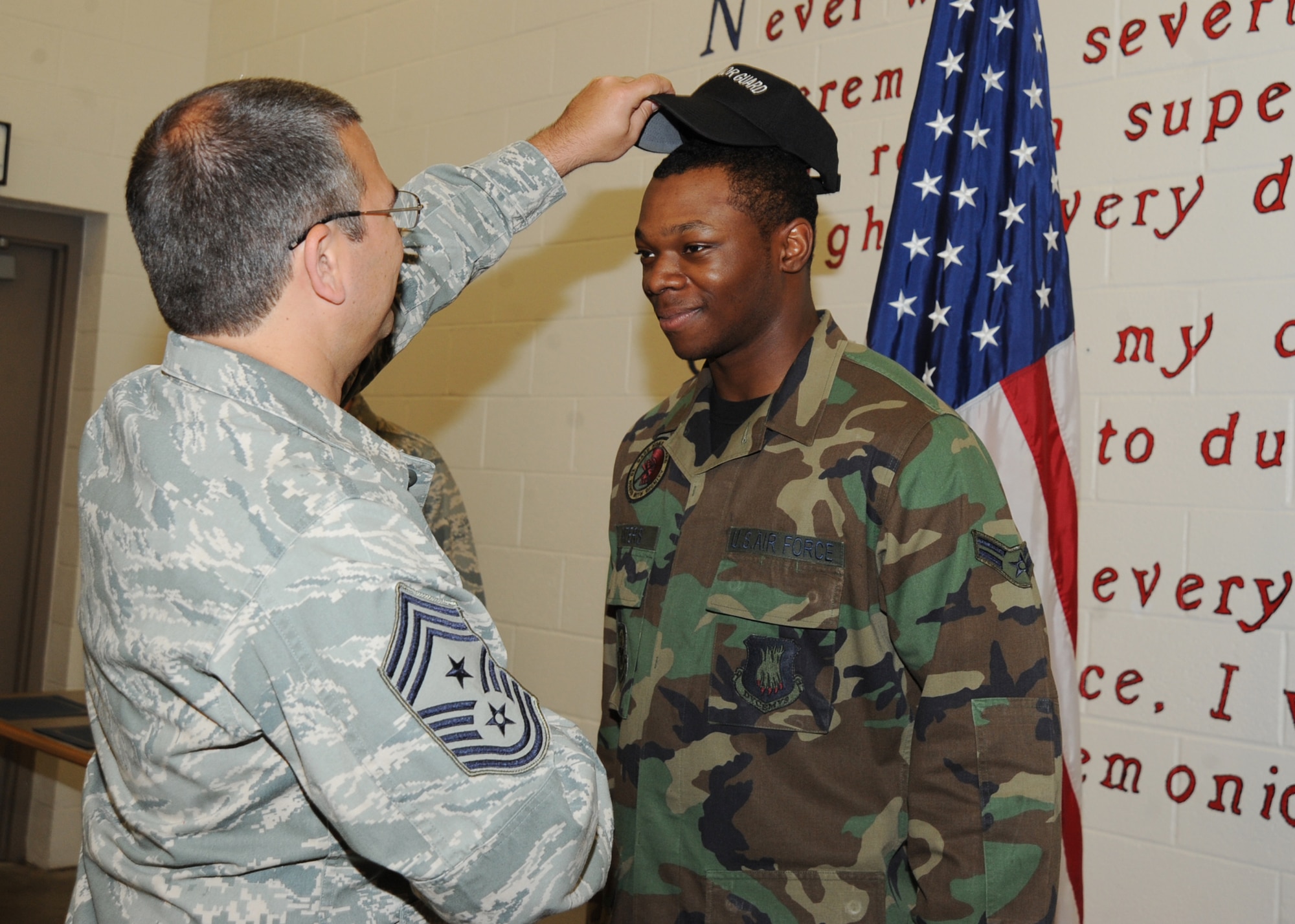 Chief Master Sgt. Timothy Horn, 22nd Air Refueling Wing command chief, places a black hat on Airman 1st Class John Gaters, 22nd Civil Engineer Squadron electrical system apprentice, during a black hat ceremony held in the base honor guard facility May 28, 2010, McConnell Air Force Base, Kan. The ceremony presents a black hat, certificate, coin and a t-shirt to distinguished Airmen within the honor guard. Honor guard members must accomplish at least three months of honor guard duty, 20 details, six details in a leadership position, complete a practical test given by three black hat recipients, pass a written test with an 80 percent or better and have the NCOIC of honor guard recommendation to receive the black hat. McConnell currently has 12 honor guard members who are honored with the black hat. (U.S. Air Force photo/Senior Airman Maria Ruiz) 