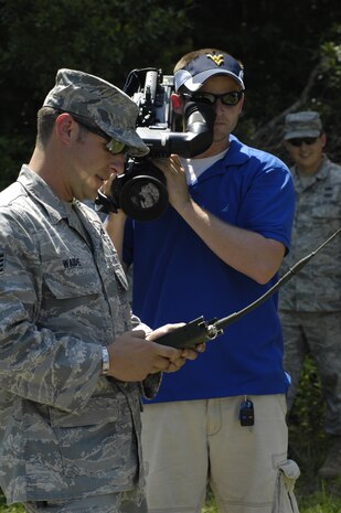 Dave McQueen films U.S. Air Force Staff Sgt. Brandon Waide as he operates a remote control used to detonate two blocks of C-4 explosives during the Explosive Ordnance Disposal Media Day on Joint Base Charleston, S.C., May 7, 2010. The two blocks of C-4 are the maximum amount of explosives which can be detonated on the range at JB CHS. Members of the local media were invited to come learn about what EOD does. Sergeant Waide is an EOD technician with the 628th Civil Engineer Squadron. Mr. McQueen is a videographer with ABC News Channel 4. (U.S. Air Force Photo/Airman 1st Class Lauren Main)