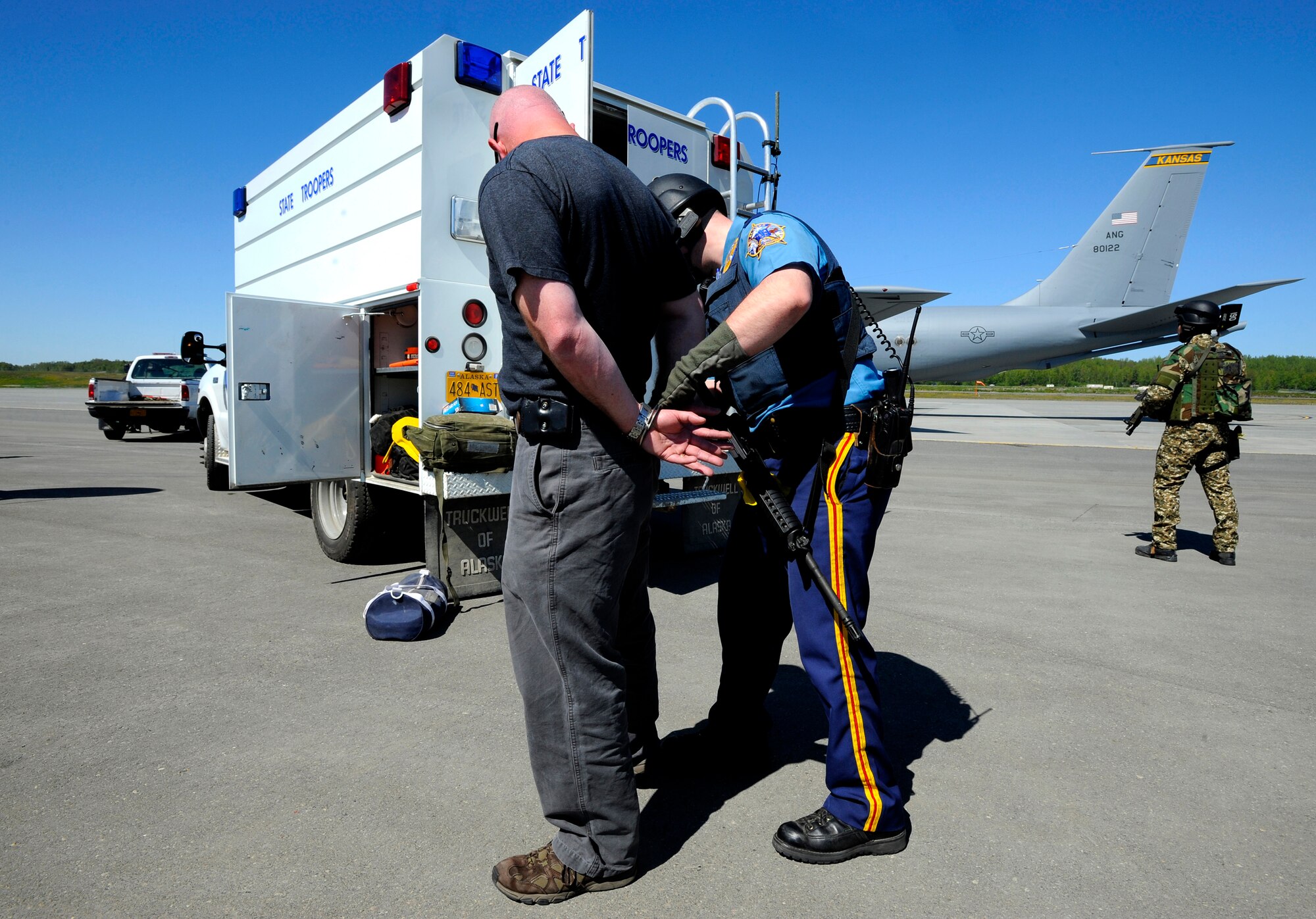 An Alaska State Trooper processes a suspected terrorist during Arctic Fencing Inter-Agency Arrow 2010 field training exercise May 26. During this exercise Department of Defense, Department of Justice and Department of Homeland Security personnel worked together to resolve a simulated terrorist hijacking of a commercial aircraft from the initial in flight tactical response until the aircraft was safely escorted to the airport and secured by agents on the ground. (U.S. Air force photo/Staff Sgt. Brian Ferguson)