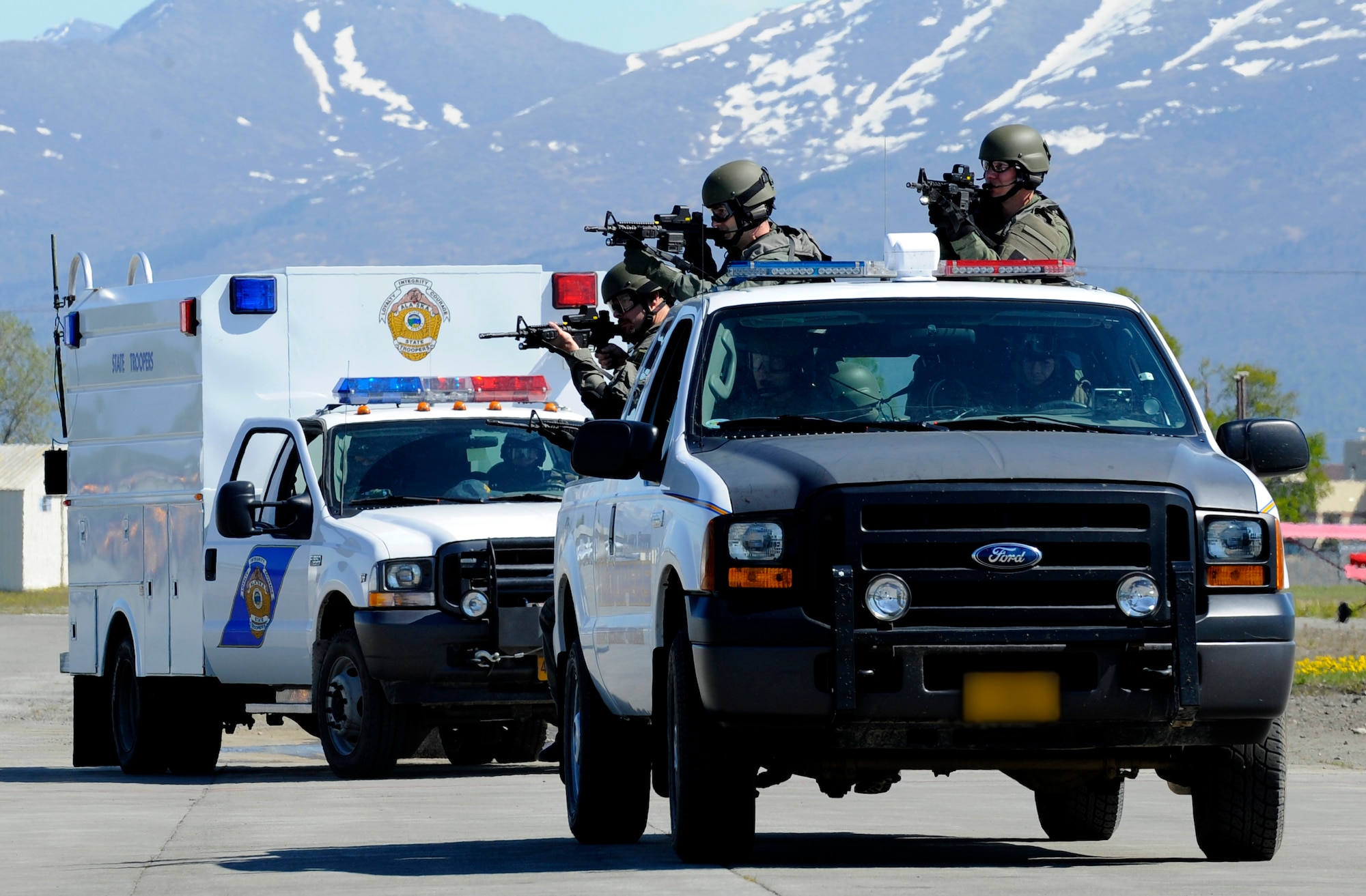 A Federal Bureau of Investigation and Alaska State Trooper joint SWAT team move toward an aircraft during Arctic Fencing Inter-Agency Arrow 2010 field training exercise May 26. During this exercise Department of Defense, Department of Justice and Department of Homeland Security personnel worked together to resolve a simulated terrorist hijacking of a commercial aircraft from the initial in flight tactical response until the aircraft was safely escorted to the airport and secured by agents on the ground. (U.S. Air force photo/Staff Sgt. Brian Ferguson)