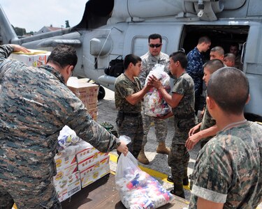 Guatemalan military members along with U.S. servicemembers load more than 1,000 pounds of humanitarian aid on to a SH-60F Seahawk June 2 at the Guatemala City Airport. At the request of the Guatemalan government, U.S. military aircraft conducted their first humanitarian missions to support humanitarian assistance efforts in Guatemala following Tropical Storm Agatha. (U.S. Air Force photo by Staff Sgt. Bryan Franks)
