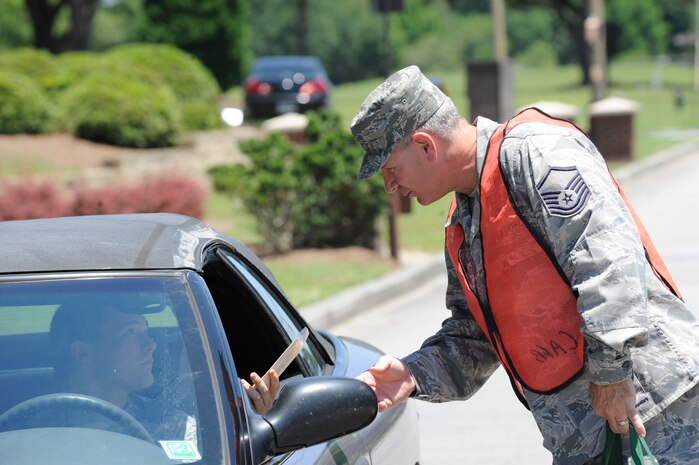 U.S. Air Force Master Sgt. Terry Harrelson hands out a Safety Send Off wooden plane May 27, 2010, at Joint Base Charleston, S.C. The Safety Send Off is a reminder to Airmen and civilians at JB CHS to have a safe weekend. Sergeant Harrelson is with the 628th Contracting Squadron (U.S. Air Force photo/James M. Bowman)