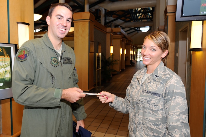 U.S. Air Force 1st Lt. Rebecca Rupp gives Staff Sgt. Alan Lotspeich a Safety Send Off wooden plane May 27, 2010, at Joint Base Charleston, S.C. The Safety Send Off is a reminder to Airmen and civilians at JB CHS to have a safe weekend. Lieutenant Rupp is a section commander at the 437th Aerial Port Squadron and Sergeant Lotspeich is a communication specialist with the 437th Operations Group. (U.S. Air Force photo/James M. Bowman)