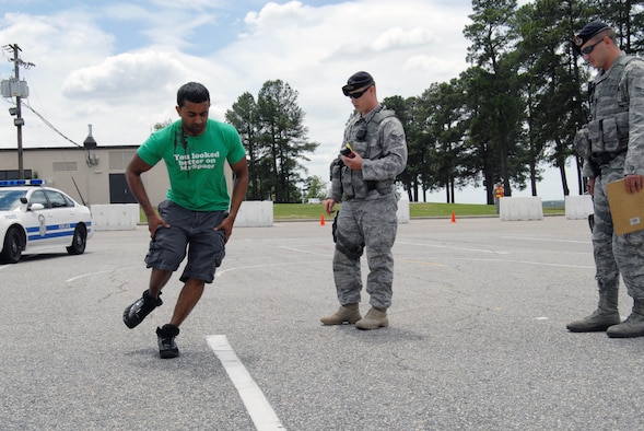 Senior Airman Christopher Crum, 43rd Security Forces Squadron, simulates administering a sobriety test to Staff Sgt. Mark Nasirali, 43rd Logistics Readiness Squadron, during the 101 Critical Days of Summer demonstration at the Pope Theater, May 27. The 101 CDS began May 28 and lasts through Labor Day. (U.S. Air Force Photo/1st Lt. Cammie Quinn)