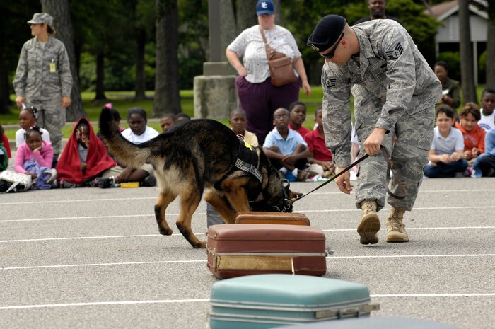 U.S. Air Force Staff Sgt. Clifford Hartley handles a military working dog during a demonstration of the dog's sensing abilities for North Charleston Elementary School students at Joint Base Charleston, S.C., May 26, 2010. During the demonstration, the dog followed commands given by his handler and correctly identified which suitcase contained a hazardous explosive device. Sergeant Hartley is a working dog handler with the 628th Security Forces Squadron. (U.S. Air Force Photo/Airman 1st Class Lauren Main)