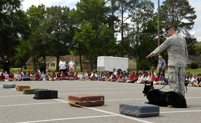 U.S. Air Force Senior Airman Brandon Edwards demonstrates the honed sensing abilities of a military working dog to approximately 260 students from North Charleston Elementary School at Joint Base Charleston, S.C., May 26, 2010. The base visit was an educational reward for nearly 75 percent the school's grade K-5 students who completed the "Revving It Up For Reading" program. Airman Edwards is a working dog handler with the 628th Security Forces Squadron. (U.S. Air Force Photo/Airman 1st Class Lauren Main)
