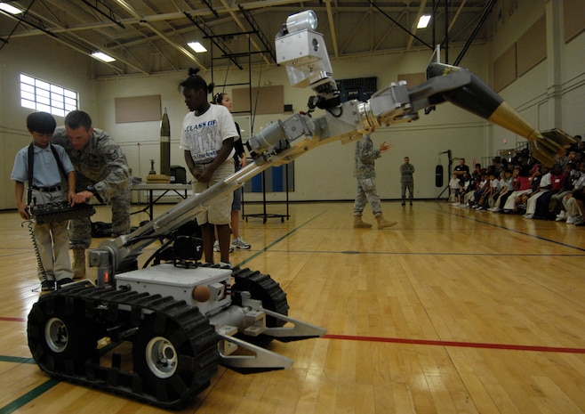 U.S. Air Force Staff Sgt. Steven Stone assists a North Charleston Elementary School student in operating a robot at the Fitness and Sports Center on Joint Base Charleston, S.C., May 26, 2010. During the demonstration, Airmen trained in explosive ordnance disposal educated students about their professions and explained their deployed duties. Sergeant Stone is an EOD technician with the 628th Civil Engineer Squadron. (U.S. Air Force Photo/Airman 1st Class Lauren Main)