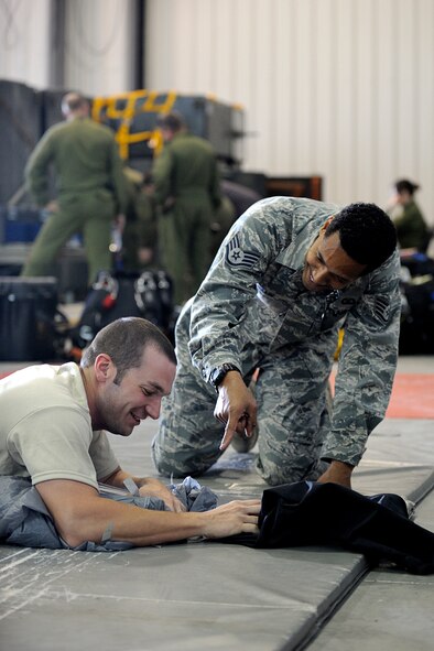 17 WING WINNIPEG, MANITOBA, Canada, - Staff Sgts'. Josh Yarbrough and Carlous Gillis, both reservists from the 920th Rescue Wing, Patrick Air Force Base, Fla., pack parachutes for the 920th RQW pararescuemen during the 2010 Grand Prairie, Alberta search and rescue exercise. From May 14-18, 2010, the reservists along with members of Canad's 435 Search and Rescue Squadron, out of Winnipeg Manitoba, 440 Squadron from Yellowknife, along with members of Civil Air Search and Rescue Association (CASARA) and various other local emergency response groups and organizations in Grande Prairie Alberta, all participated in the SAREX. The exercise consisted of searches from the air, PJs parachuting, casualty air extraction by STARS and ground evacuation by local EMS technicians. The exercise also consisted of precision aircraft landing by HC-130 Hercules aircraft (both American and Canadian) as well as accuracy cargo drops and parachute accuracy jumps. (U.S. Air Force photo by Corporal Colin Aitken) 
