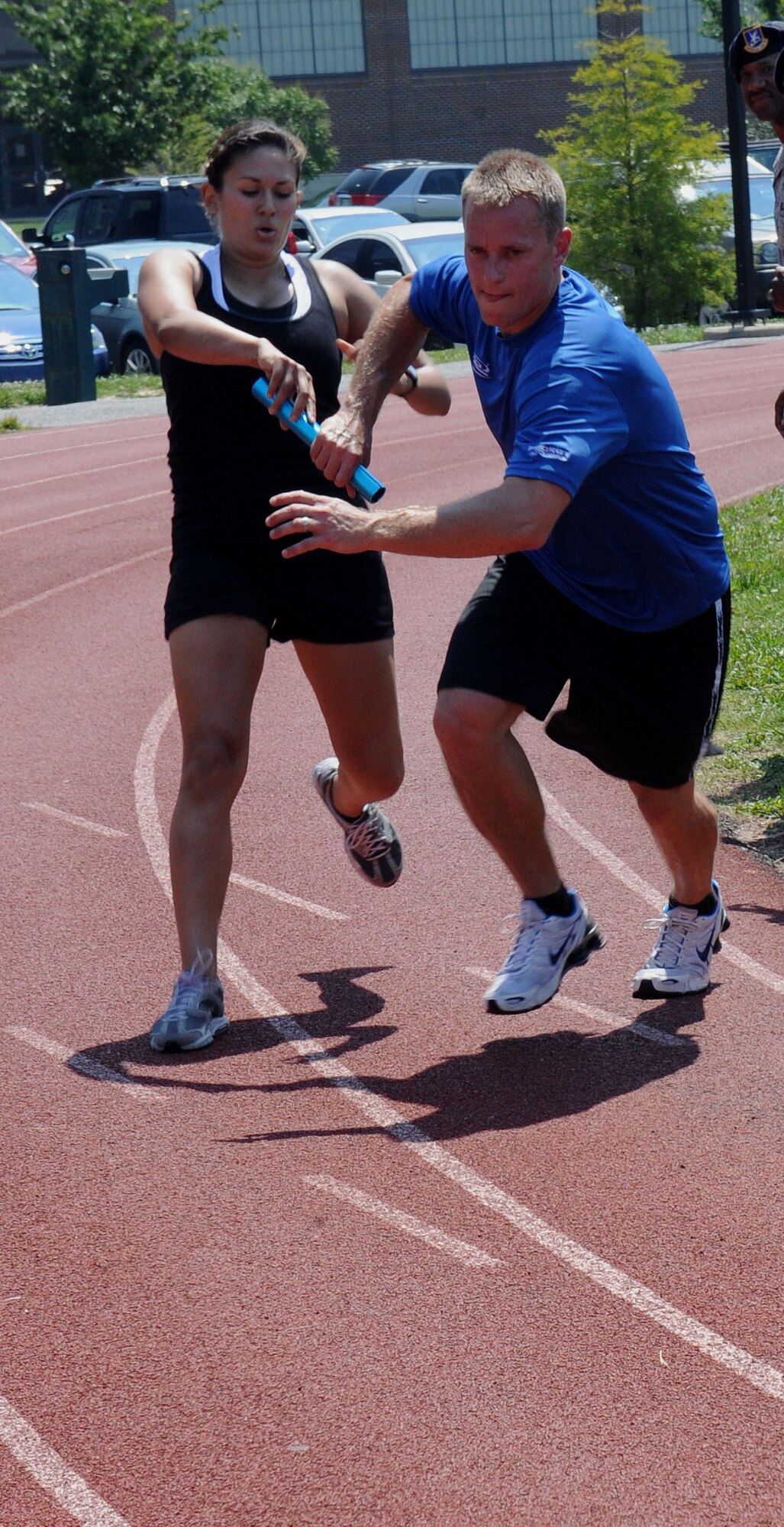 LANGLEY AIR FORCE BASE, Va. -- 1st Lt. Krista Barajas, 633d Force Support Squadron fitness assessment cell officer in charge, passes the baton to Chris Bendix, 633d Force Support Squadron fitness testing technician, during the Squadron Fitness Challenge 1.5 mile relay run May 27. The Squadron Fitness Challenge is an annual event wrapping up May fitness month and was hosted by the 633d Force Support Squadron and Prism Sports to promote a healthy, active lifestyle.  (U.S. Air Force Photo/Staff Sgt. Christina M. Styer) 
