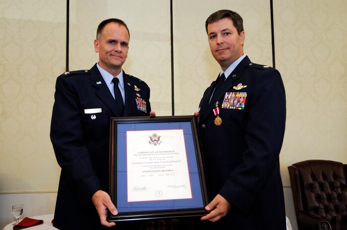 U.S. Air Force Col. Johnny Roscoe presents U.S. Air Force Lt. Col. Jesse Strickland with a retirement certificate at Joint Base Charleston, S.C., May 27, 2010. Colonel Strickland retired after more than 22 years of dedicated service. Colonel Roscoe is chief of international affairs for U.S. Africa Command, Division Deputy Under Secretary of the Air Force, and Colonel Strickland most recently served as chief of Aircrew Standardization and Evaluation for the 437th Operations Group. (U.S. Air Force photo by James M. Bowman/Released)