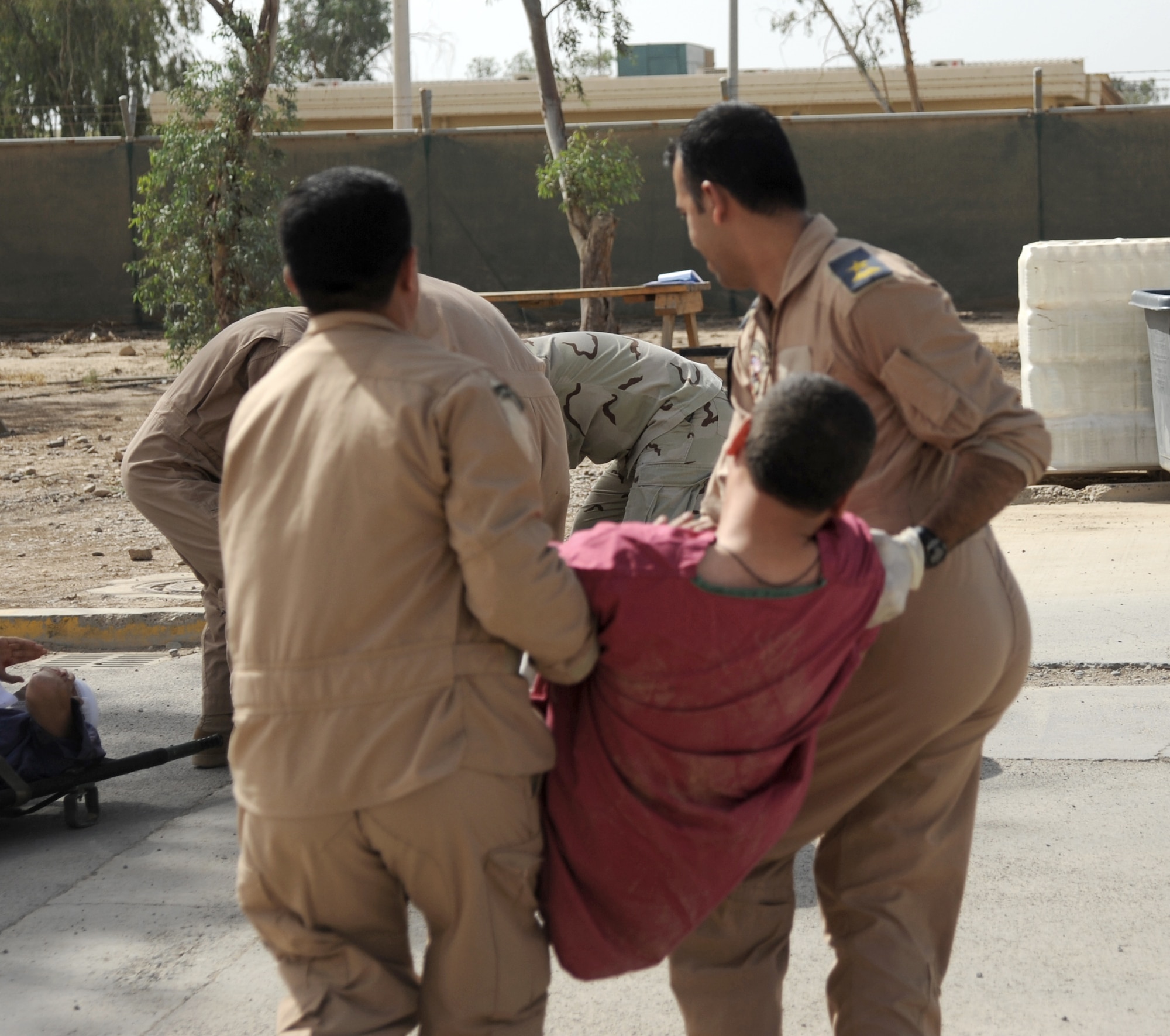 Iraqi military members carry a victim with simulated injuries to a safe point to provide him with medical treatment during a training exercise May 20, 2010, at Joint Base Balad, Iraq. Iraqi forces from Al-Muthana, Camp Taji and New Al-Muthana participated in an exercise that demonstrated their abilities to assess and treat different conditions that may happen in a combat environment. (U.S. Air Force photo)